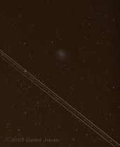 An aircraft passes Comet Holmes